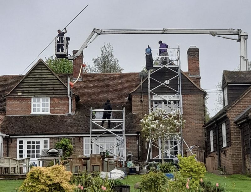 The Moss Cleaners using cherry picker and scaffolding to clean roof safely and professionally in Ashtead, {{COUNTY}}